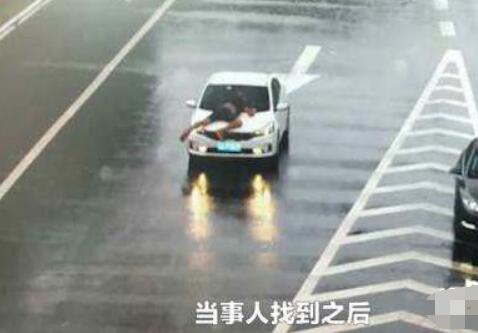 男子被顶引擎盖雨中疾驰