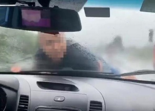 男子被顶引擎盖雨中疾驰